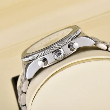 Photograph of a silver chronograph watch with a knurled bezel three pushers and a metal link bracelet displayed on an off-white watch stand