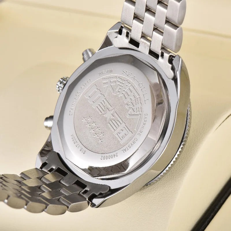 Photograph of a Sea-Gull stainless steel watch caseback featuring prominent engraved Chinese characters, 'Sapphire Crystal' text, and a polished metal bracelet, resting on a light beige display
