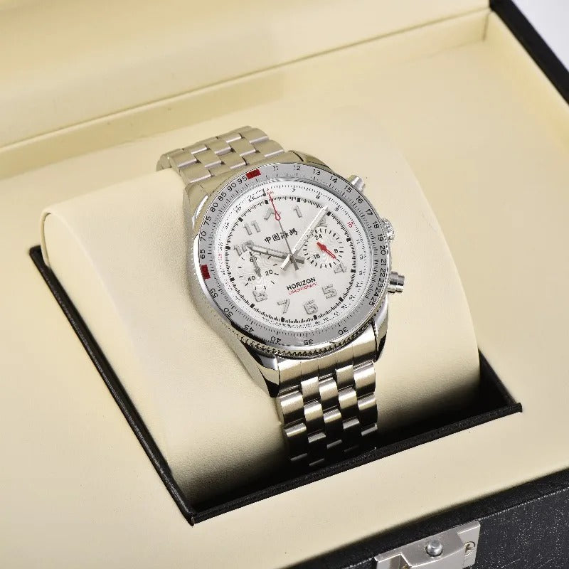 A silver-toned Horizon Chronograph watch with a white dial, red accents, and Chinese characters displayed on a cream pillow inside an open black presentation box